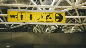 Skylt på offentlig plats som visar vägen till toalett med skötbord